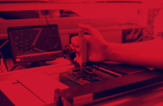 Rötliches Bild - Eine Person hält ein Gerät in der Hand zur Chip Produktion.